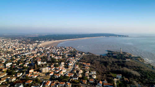 High angle view of townscape by sea against clear sky