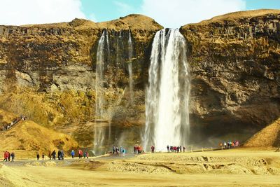 Panoramic view of people at waterfall