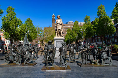 Statues against trees and blue sky