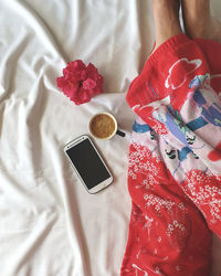 High angle view of woman in bed with coffee 