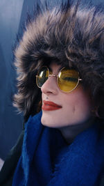 Close-up of young woman in fur coat and sunglasses