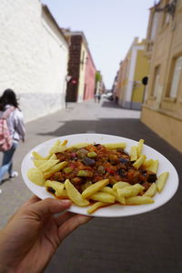 Cropped image of person holding food on building