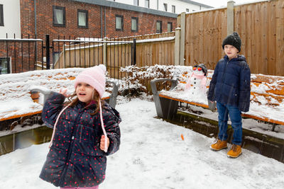 Happyboy and girl standing in snow