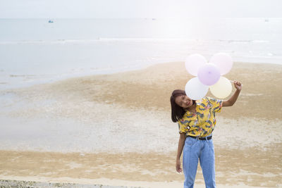 Asian young girl enjoy time playing balloone at the beach.