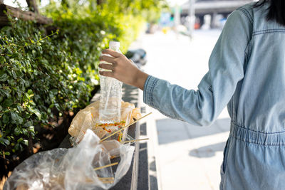 Midsection of man holding ice cream standing outdoors