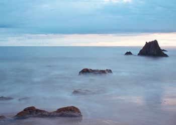 Scenic view of rocks in sea against sky