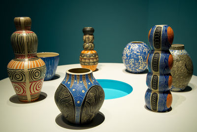 Close-up of vase on table against blue background