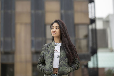 Portrait of smiling young woman standing outdoors