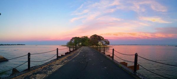 Pier on sea at sunset