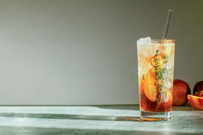 Peach iced tea or long island iced tea cocktail in glass with straw. summer refreshing fruit drink