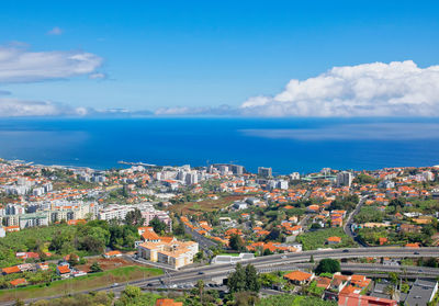 High angle view of townscape by sea against sky