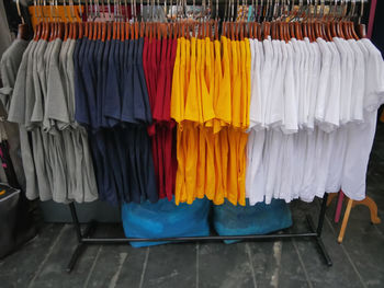 Colorful t-shirts hanging on rack at retailed store