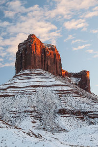 Rock formations on snow covered mountain against sky