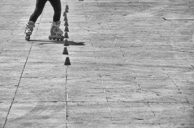 Low section of child roller skating on street