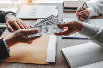 Cropped hands of business colleagues working on table