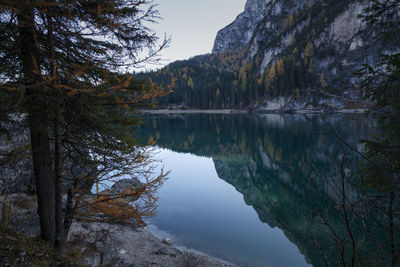 Scenic view of lake by trees against sky in dolomites mountains 