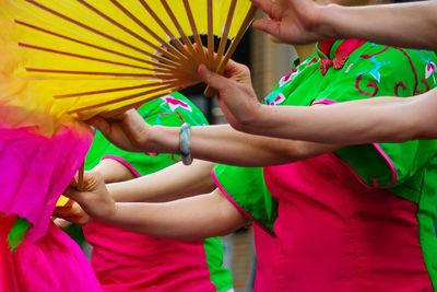 Women in traditional costume while dancing with folding fans at parade