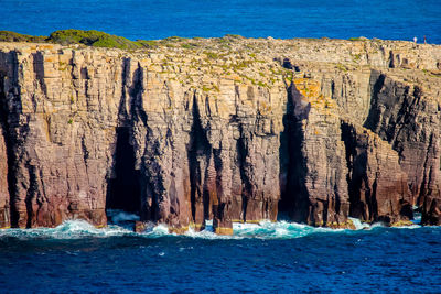 Scenic view of sea against rock formation