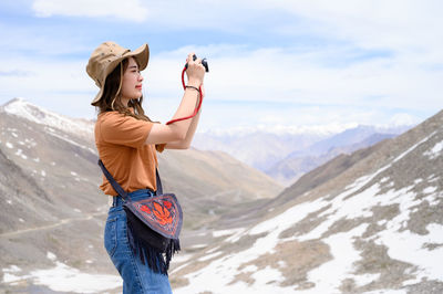 Full length of woman standing on mountain against sky