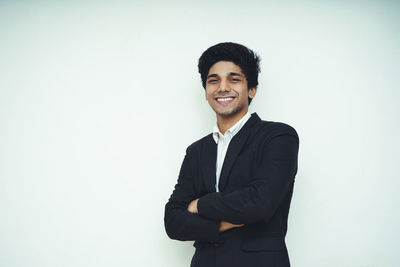 Portrait of smiling young man against white background