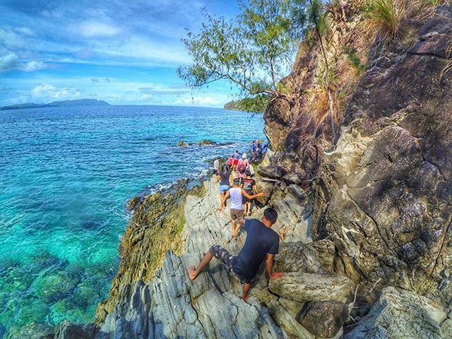 water, sea, leisure activity, lifestyles, rock - object, beauty in nature, sky, scenics, tranquility, rock formation, tranquil scene, nature, men, vacations, cliff, horizon over water, full length, rock