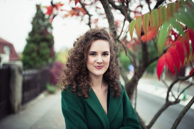 Beautiful young woman in a green coat in an autumn park. street portrait, fall season 