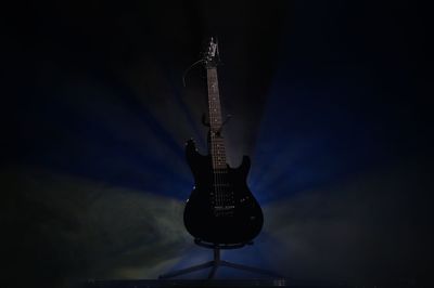 View of guitar against black background