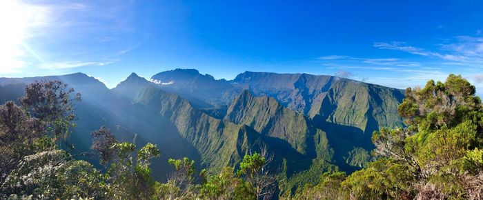 Scenic view of mountains against blue sky