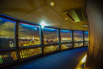 Illuminated cityscape seen through window at night