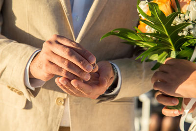 Midsection of bride and groom during wedding 