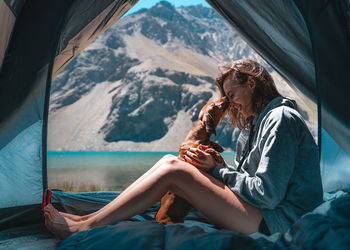 Side view of young woman sitting outdoors