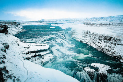 Scenic view of sea and snowcapped mountains against sky