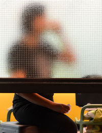 Close-up of woman on window at home