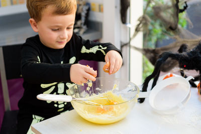 Portrait of boy eating food on table