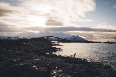 Scenic view of river against cloudy sky at sunset