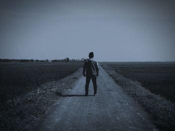 Rear view of man walking on field