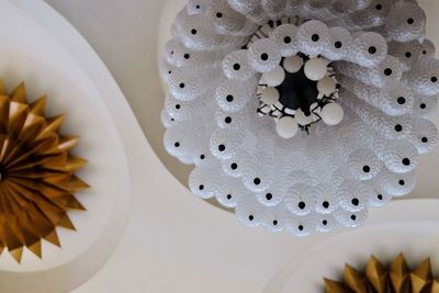 Low angle view of vintage white chandelier balls from arch ceiling 