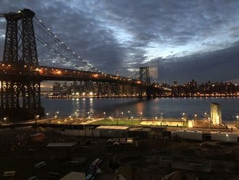 Illuminated suspension bridge over river at night