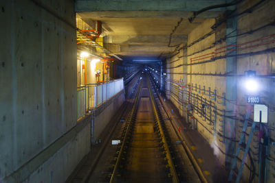 Illuminated railroad tracks in tunnel