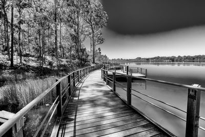 Footbridge over river against sky