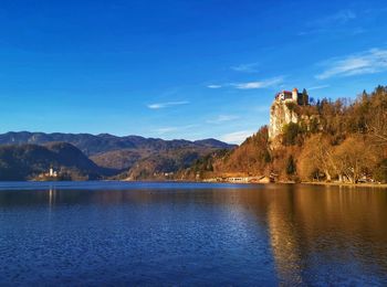 Scenic view of lake and mountains against blue sky