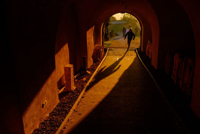 Rear view of people walking in tunnel