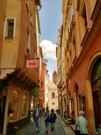 People walking on street amidst buildings in city