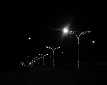 Low angle view of illuminated street lights at night