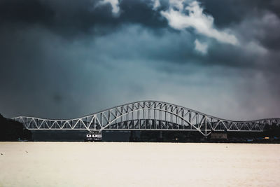 Low angle view of bridge over river against sky