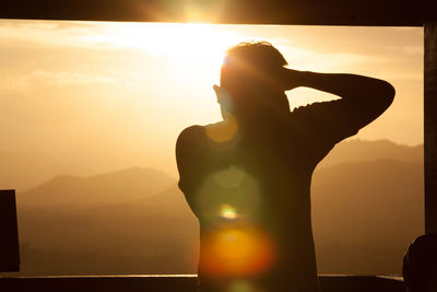 Silhouette man standing against sky during sunset