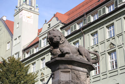 Low angle view of statue against buildings in city