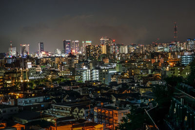 High angle view of illuminated buildings against sky at night