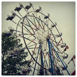 Low angle view of ferris wheel against sky