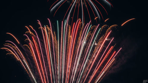 Firework display against sky at night